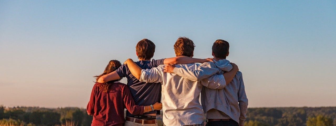 A group of young friends with their arms on each other’s shoulders