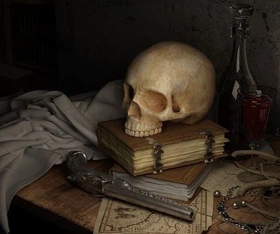 Pirate themed detritis, a skull, leatherbound books, am old fashioned pistol atop a treasure map