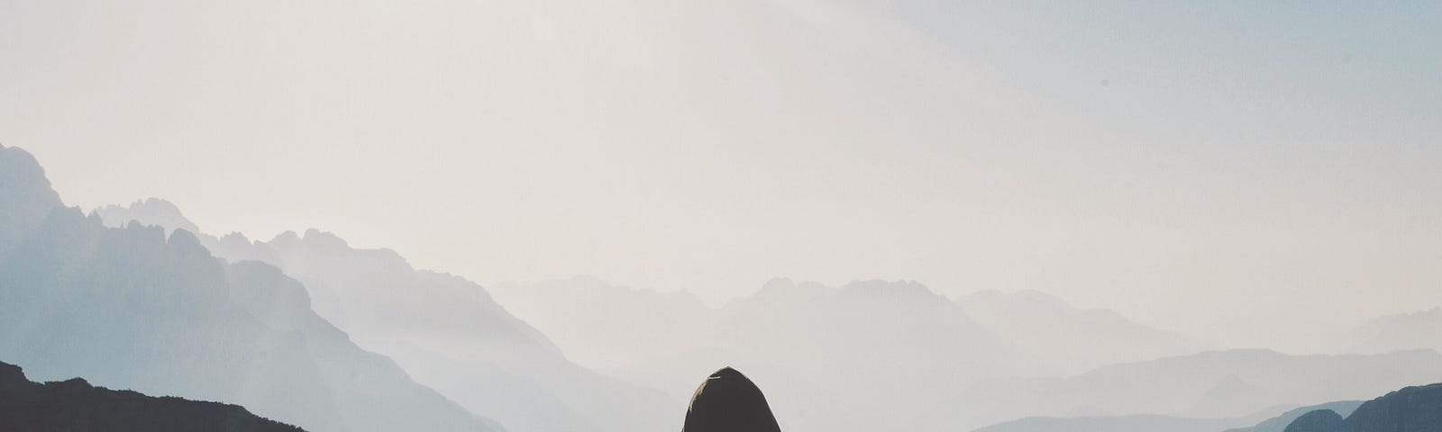Person looking at mountains from a peak