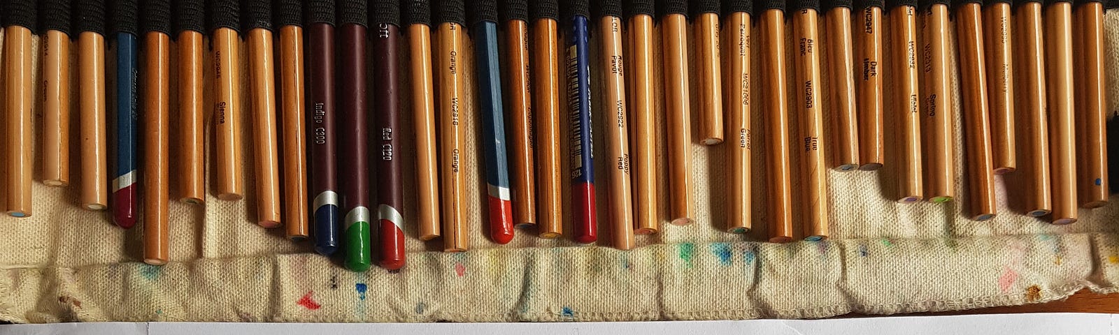 Color pencils, neatly lined up, with rose charts made of folded paper