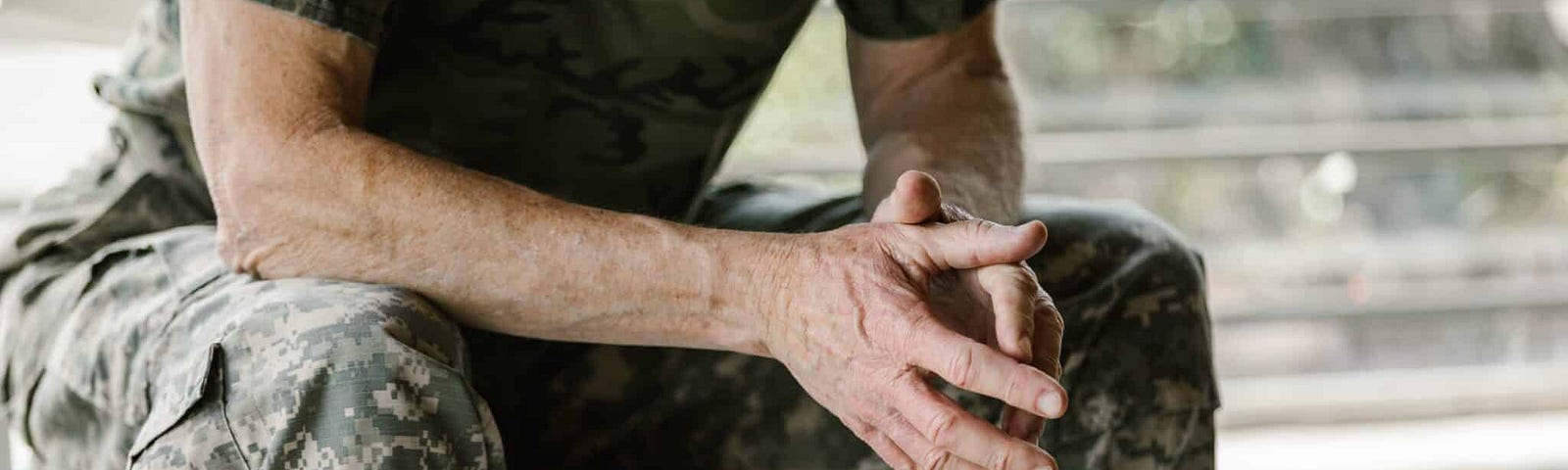 Veteran sitting with hands crossed in a counseling session.