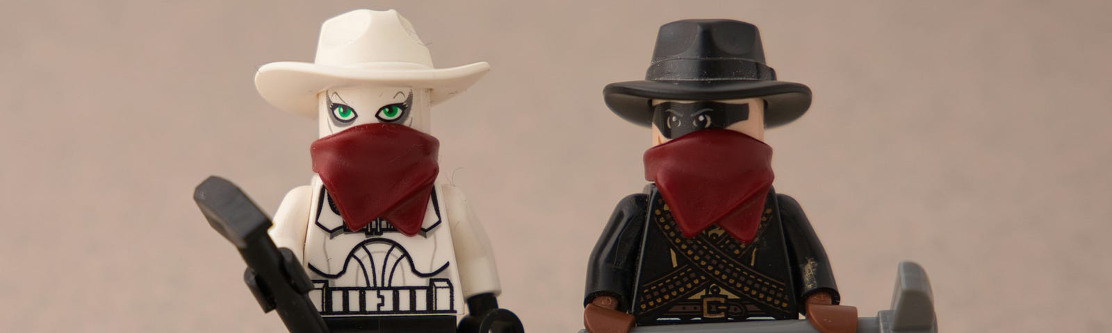 Two lego figures dressed like cowboys with bandanas over their faces