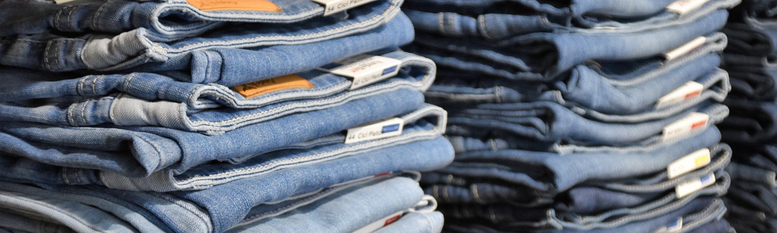 Stacks of blue jeans on a shop shelf