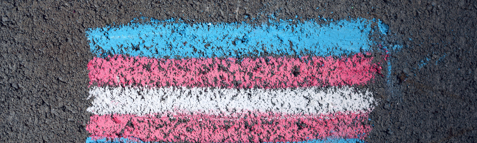 Trans flag drawn in sidewalk chalk on asphalt