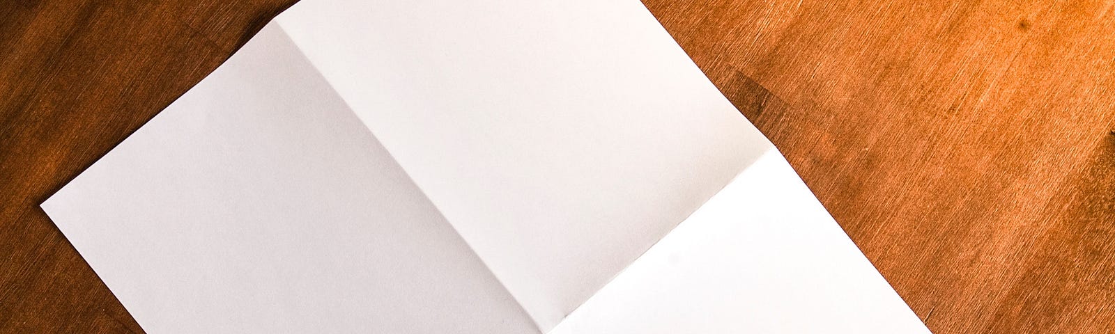 A blank piece of paper lying on a wood floor
