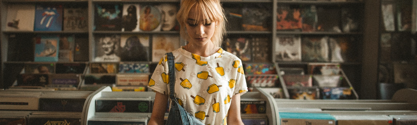A young woman looking at a record in a record store