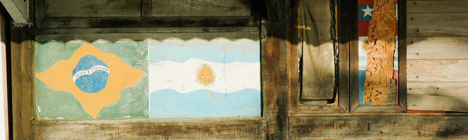 Three chairs propped against a wall. Brazil and Argentina flags are painted on the wall.