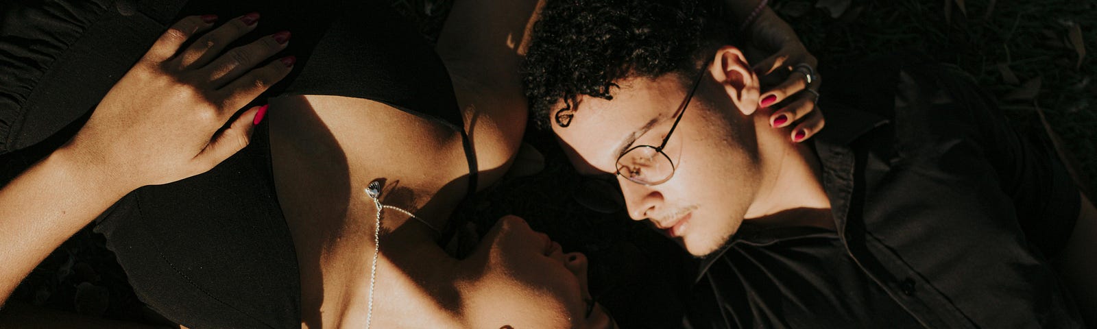 Couple in an intimate pose, wearing black.