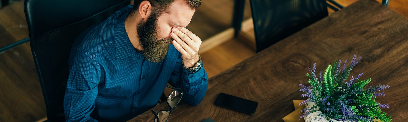 Man sitting with laptop looking frustrated