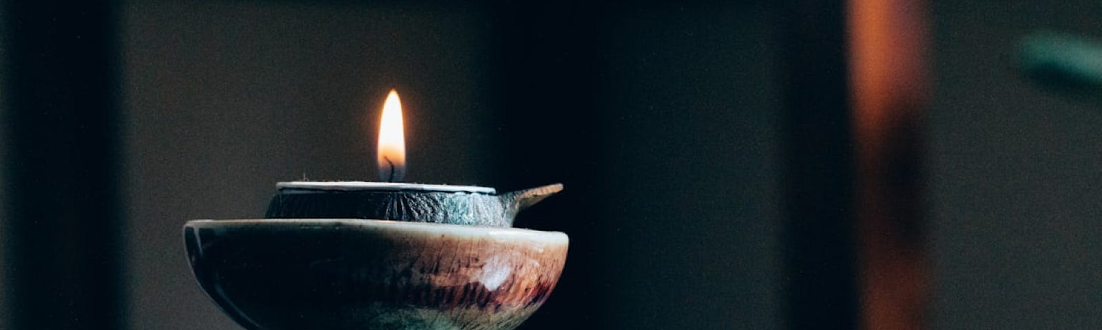 Image of a candle in a dark background. We can find our life purpose when we stop trying so hard to find it.