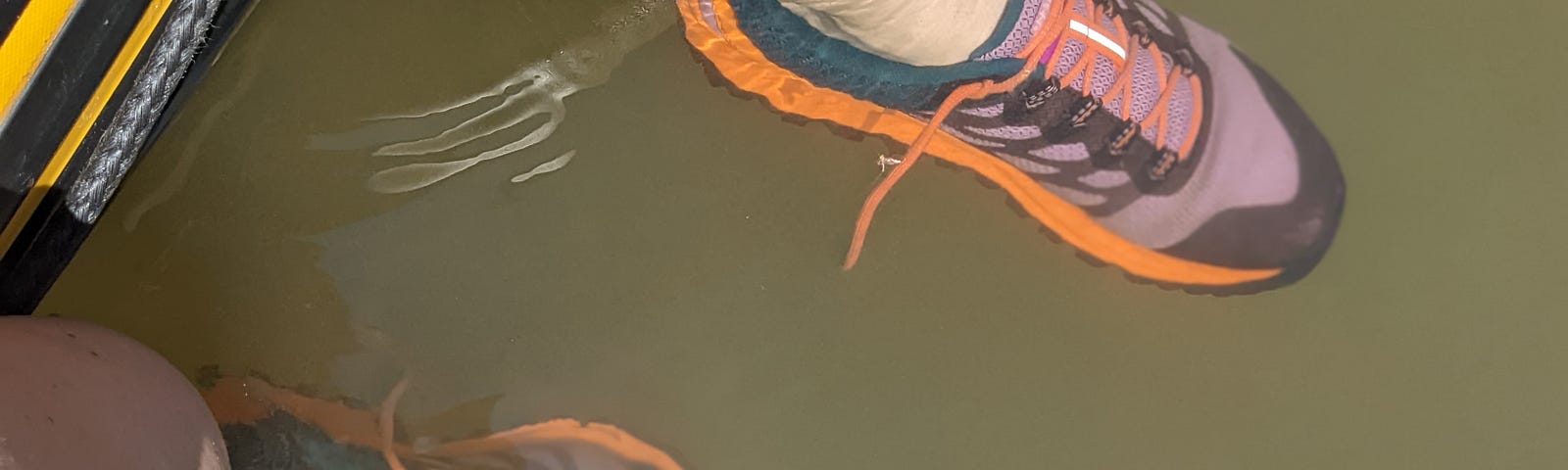 Legs with tennis shoes on floating in a river