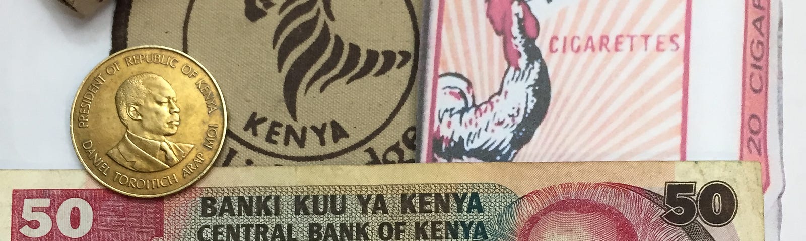 cigarettes, paper money, and a coin from Kenya