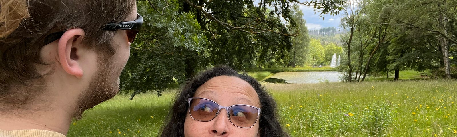 Woman looking up and to the right at a man starting out over a wooded area. She has a look of funny curiosity on her face.