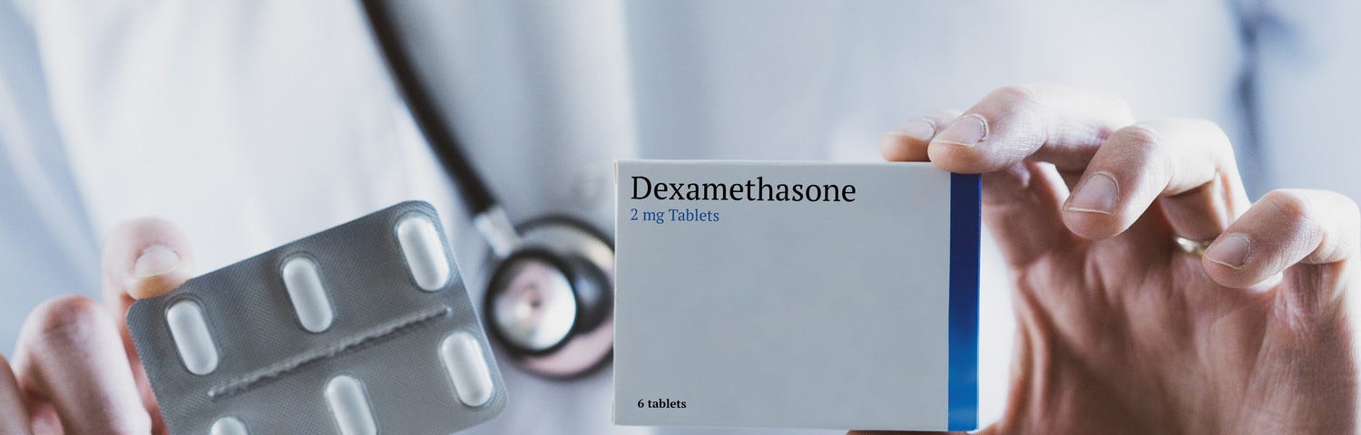 A person in a white lab coat holds a box of dexamathasone, the drug estimated to have saved a million lives worldwide from Covid-19