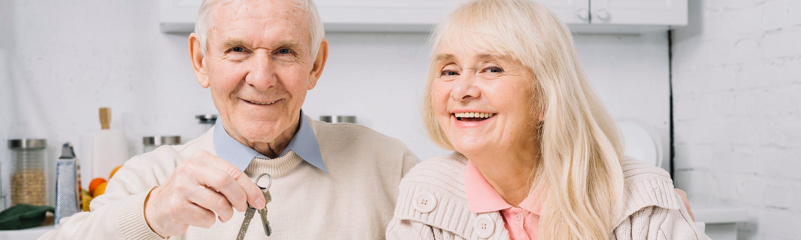 Senior elderly couple holding set of keys