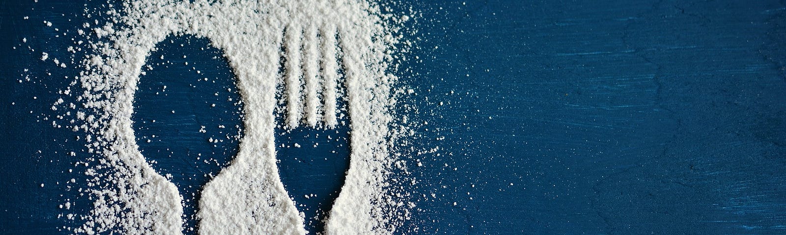 White powder (flour? sugar? cocaine?) making outline of spoon and fork