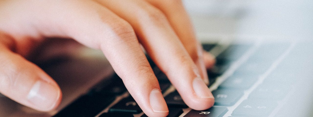An image shows a closeup shot of  a person’s hand pressing the keys on a laptop keyboard.