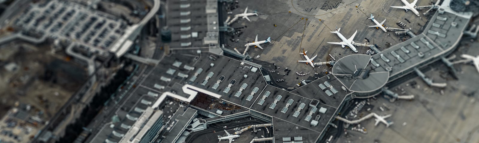 tilt shift picture of an airport terminal from the air