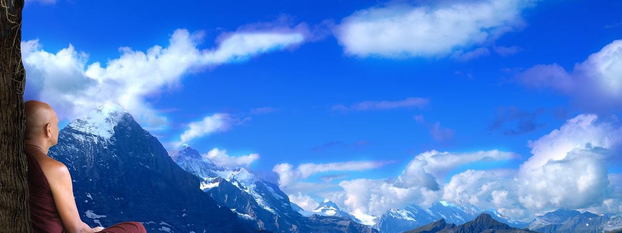 Monk meditating on top of a mountain.