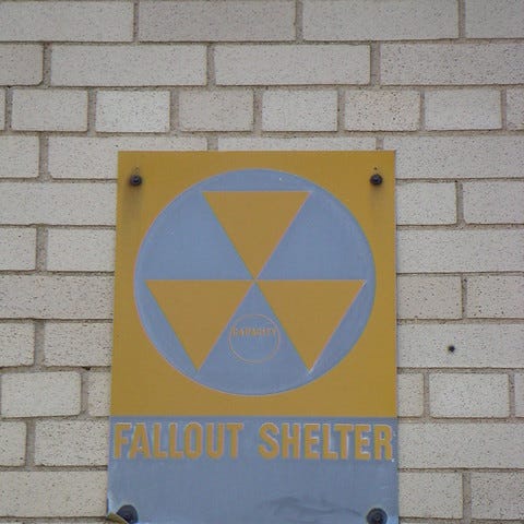 Fallout shelter sign on exterior of building.