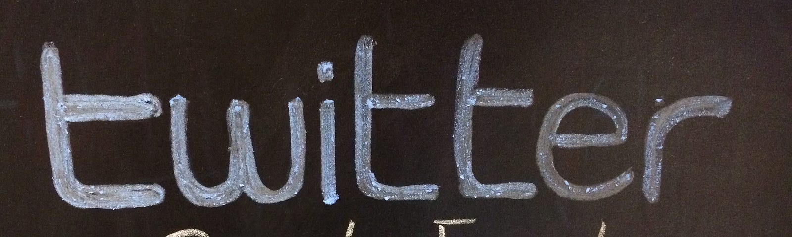 A blackboard with “Twitter” written in blue chalk and “private event” written underneath in yellow chalk.