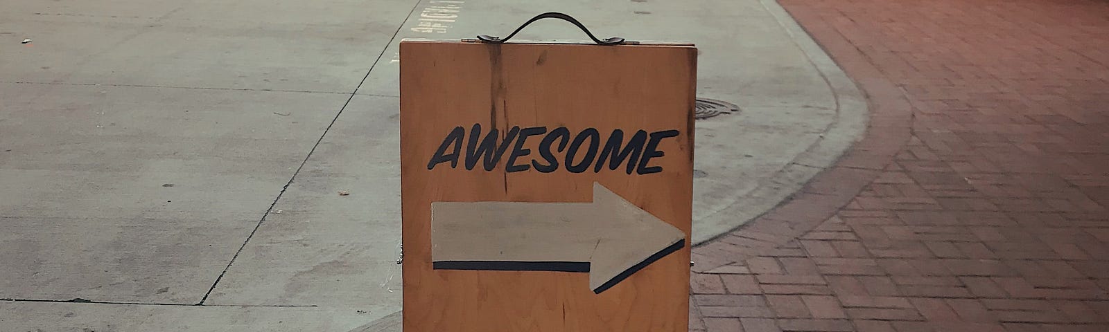 A sign on a walkway with an arrow showing left and one to the right. It reads “awesome” over the arrow leading to the right and “less awesome” over the other.