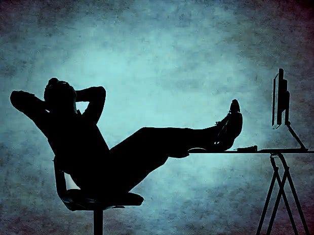 silhouette of man with feet on desk