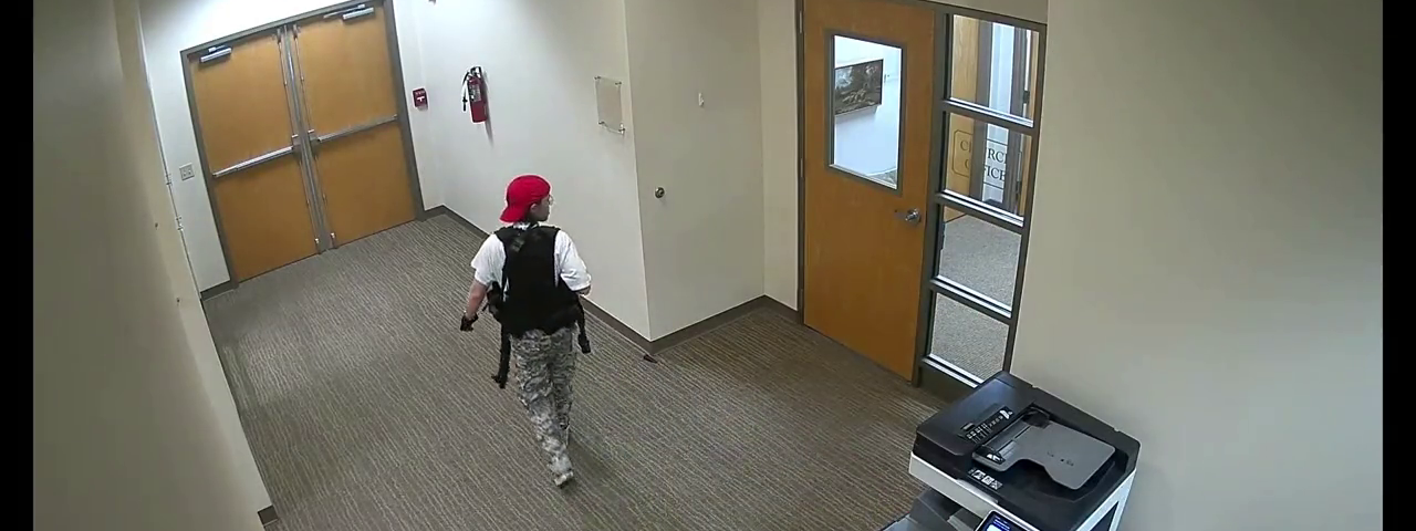 Video still of shooter walking past church office.