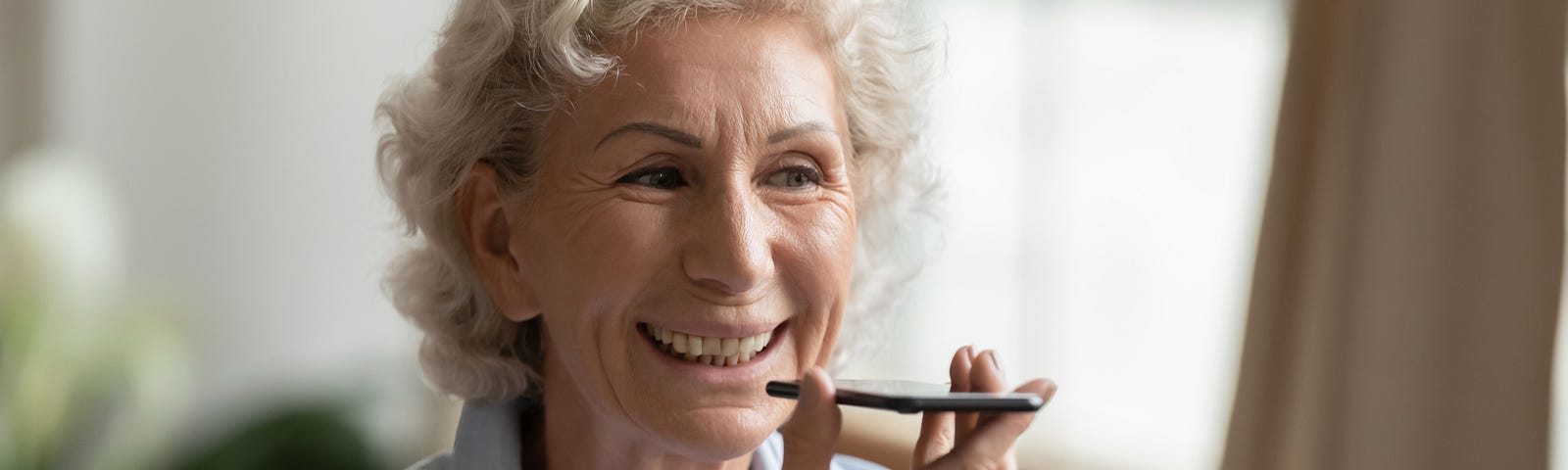 Old woman using a voice assistant on her phone.