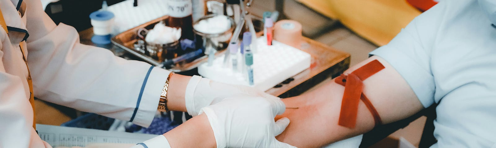 A medical professional putting a needle in a patient’s arm