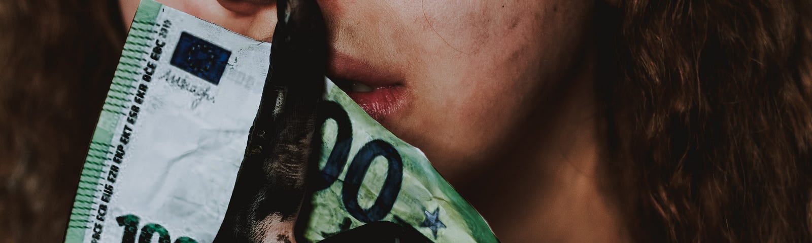 A women holds a 100 Euro Bill.