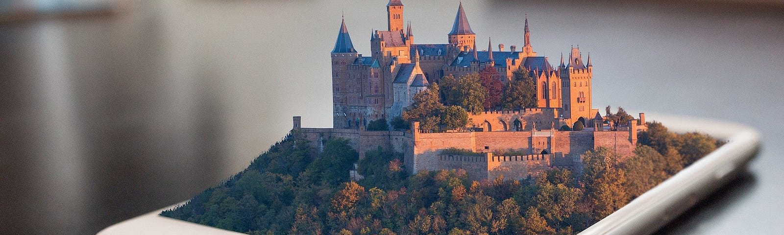 Fantasy castle emerging from the screen of a smartphone