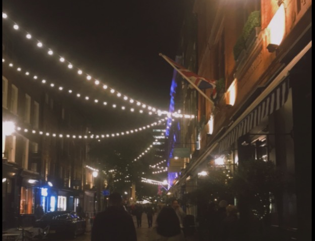 A couple walking on streets surrounded by lights