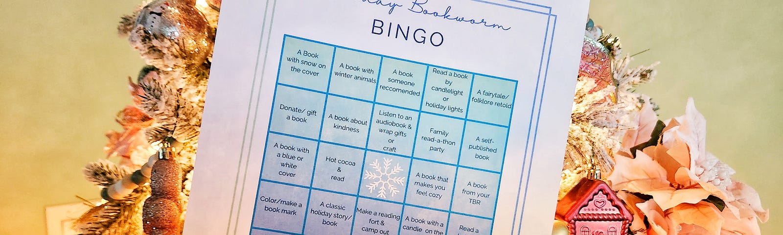 A reading challenge bingo sheet is held in front of a lit Christmas tree.