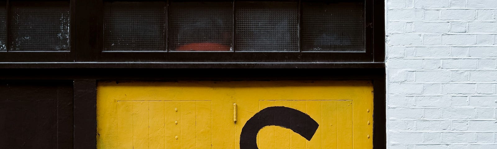 Yellow garage door painted with US as hands being held