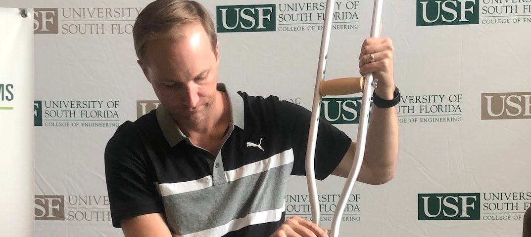 Photo of engineer with innovative crutch putter. Humor. Satire. Golf. Tiger Woods. Florida. Sports. Athletics.