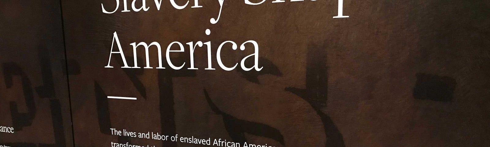 A museum sign that reads “Slavery Shapes America” with a written explanation of how slavery transformed America into a world superpower.
