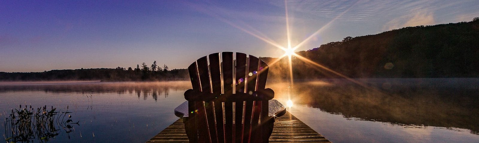 Wooden chair on a boardwalk overlooking a lake