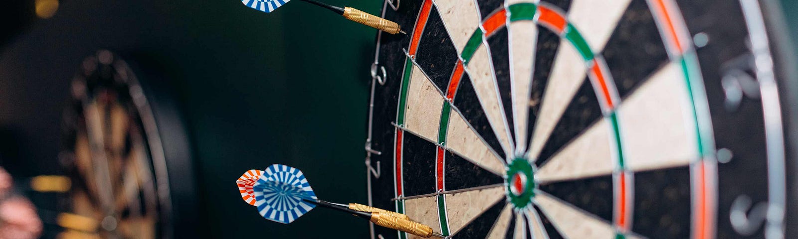 Dart board with darts sticking into the outer circle — no bullseye hits