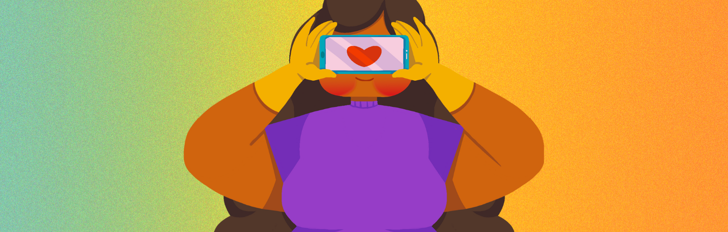 A girl holding up a phone with a love heart on the screen