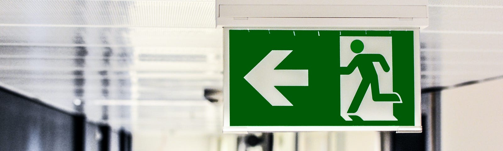 An image of an exit sign, pointing to the left of the image.