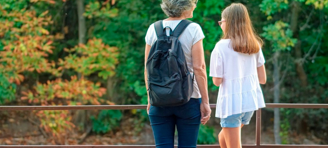 grandmother and granddaughter standing together outside