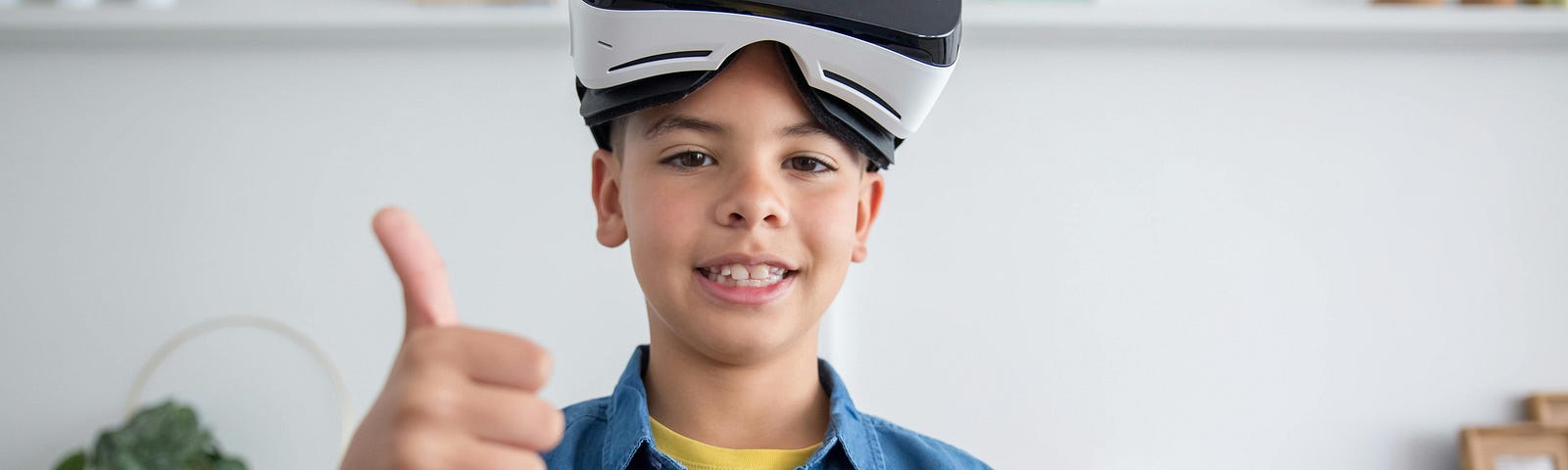 A Boy Wearing Virtual Reality Goggles with a thumbs up sign.