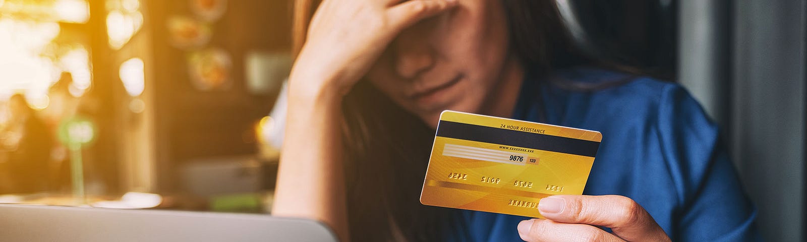 a stressed lady holding a credit card