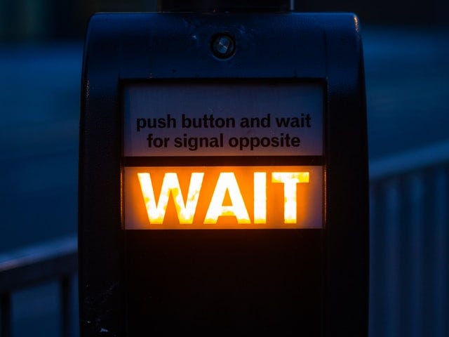 WAIT appears as a pedestrian illuminated sign