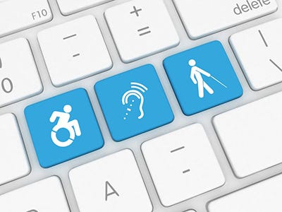 Bílá klávesnice se třemi modrými klávesy uprostřed s motivy osob s postižením (pohybovým, sluchovým a zrakovým).