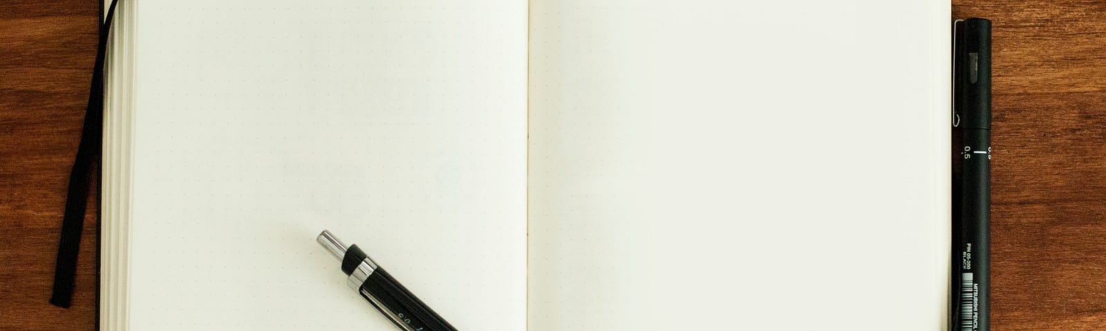 An open diary with a black pencil in it