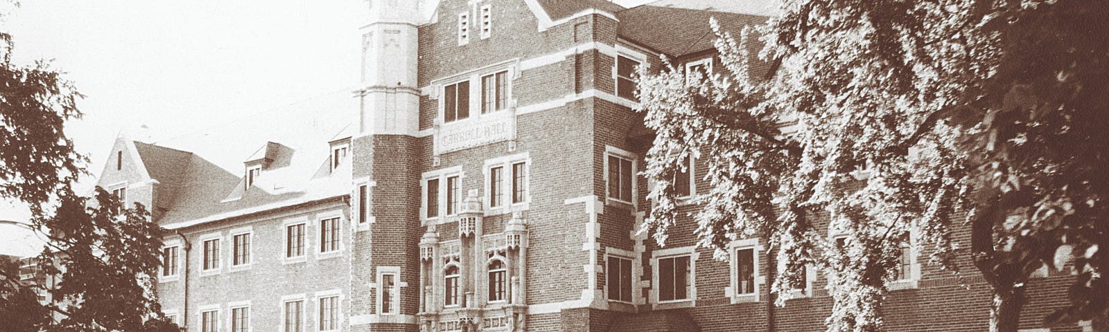 black and white photo of the exterior of Carroll Hall with old fashioned truck parked out front
