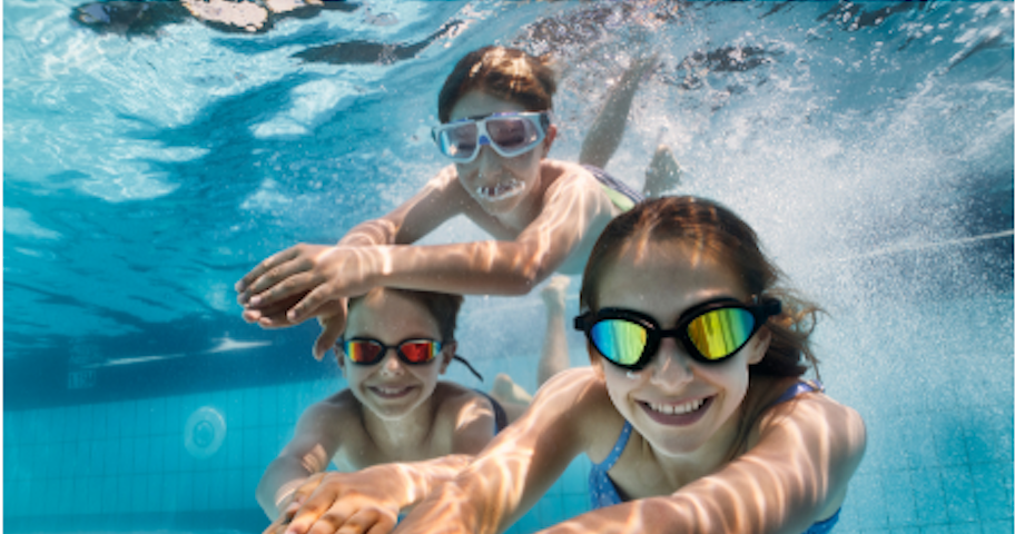 3 kids in goggles underwater in the pool