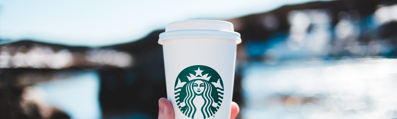 person holding white and green disposable cup